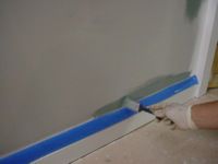 brushing paint on a wall