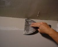 skimming a second coat of joint compound on an inside drywall corner