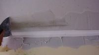 skimming the first coat of joint compound on an inside drywall corner