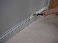 brushing paint on a base board