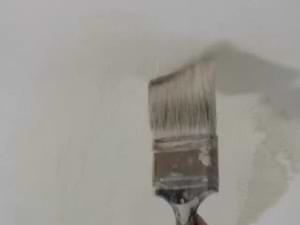 photo brushing primer-sealer on damaged ceiling