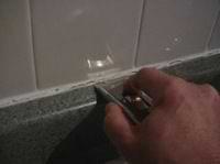 cutting away old caulk from counters