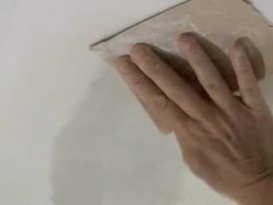 photo sanding a repaired ceiling drywall patch