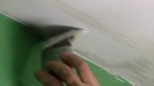 brushing paint on a ceiling with a back stroke