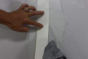 photo placing paper joint tape over a drywall seam photo placing paper joint tape over a drywall seam