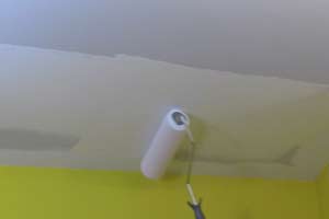photo rolling white paint onto a ceiling photo rolling white paint onto a ceiling