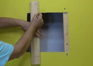 photo marking a furring strip to install in a wall hole photo marking a furring strip to install in a wall hole