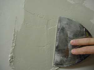 photo spreading joint compound over a patch photo spreading joint compound over a patch