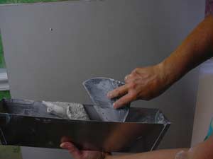 photo scooping joint compound from a mud pan photo scooping joint compound from a mud pan