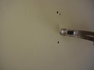 using a hammer to make a dimple over a drywall nail pop photo using a hammer to make a dimple over a drywall nail pops
