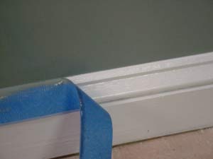 photo removing masking tape from a baseboard after painting the wall photo removing masking tape from a baseboard after painting the wall