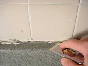 photo cutting away cracked caulk from a countertop