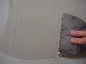 photo covering a drywall patch with mud