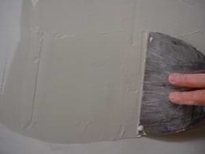 photo covering a drywall patch with mud photo covering a drywall patch with mud