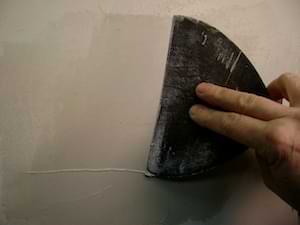 photo covering a drywall patch with mud photo covering a drywall patch with mud