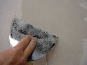 photo skimming a drywall patch with mud