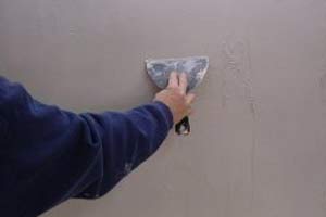 photo smoothing a second coat of joint compound over wall damage photo smoothing a second coat of joint compound over wall damage