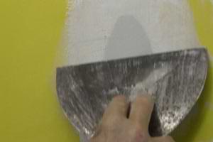 photo skimming joint compound off a torn drywall paper patch photo skimming joint compound off a torn drywall paper patch
