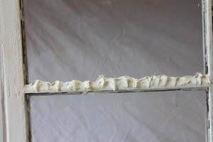photo of a window mullion with excess glazing putty applied photo of a window mullion with excess glazing putty applied